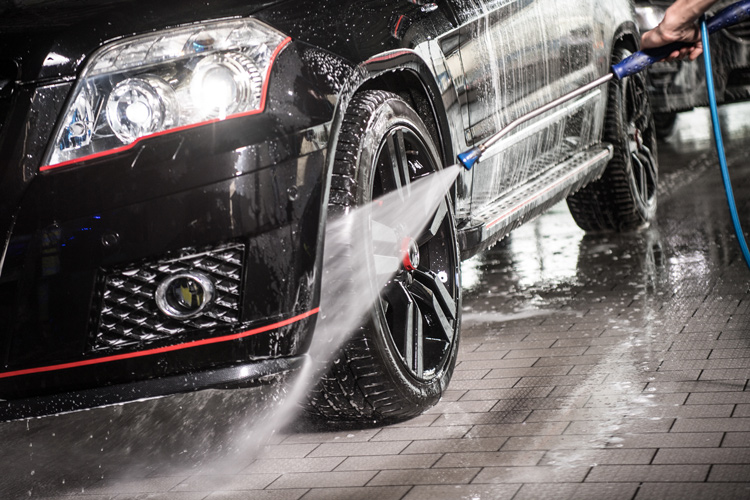 Foto eines Autoreifens mit Felge, welches mit Hochdruckreiniger gereinigt wird
