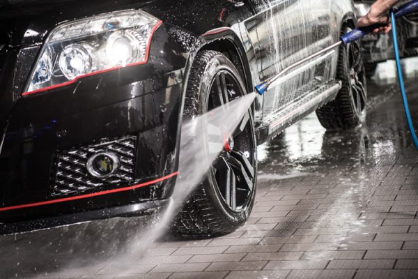 Foto eines Autoreifens mit Felge, welches mit Hochdruckreiniger gereinigt wird
